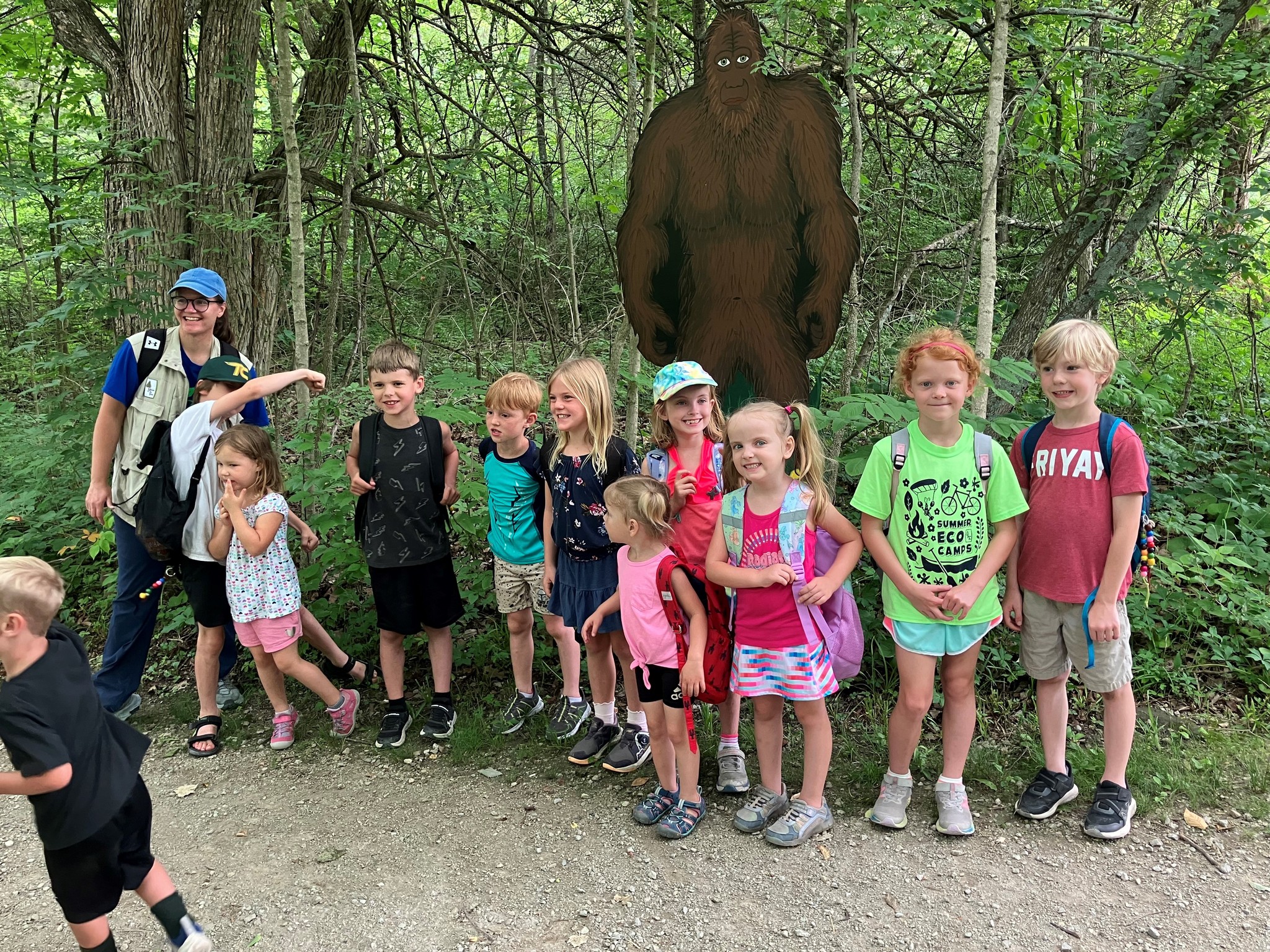 children in the woods with a big foot statue