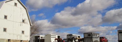 large view of blue sky, barn and horse trailers